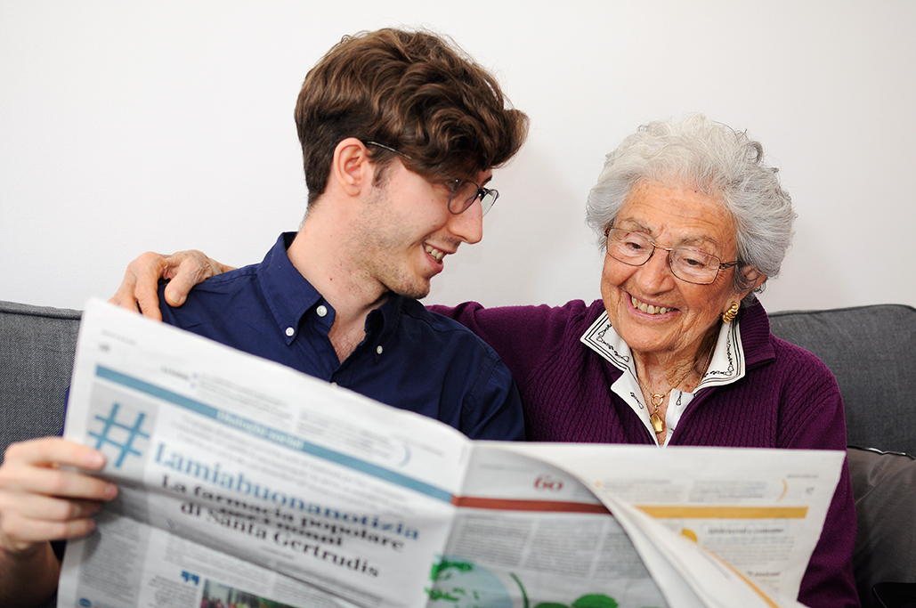 Giovane e donna anziana leggono insieme il giornale